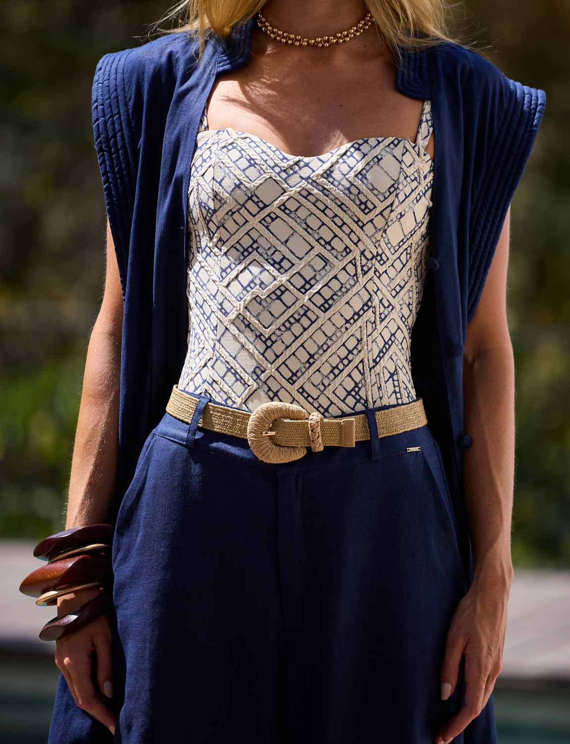 Mulher usando calça pantalona azul-marinho em composição sofisticada de resortwear Kalini