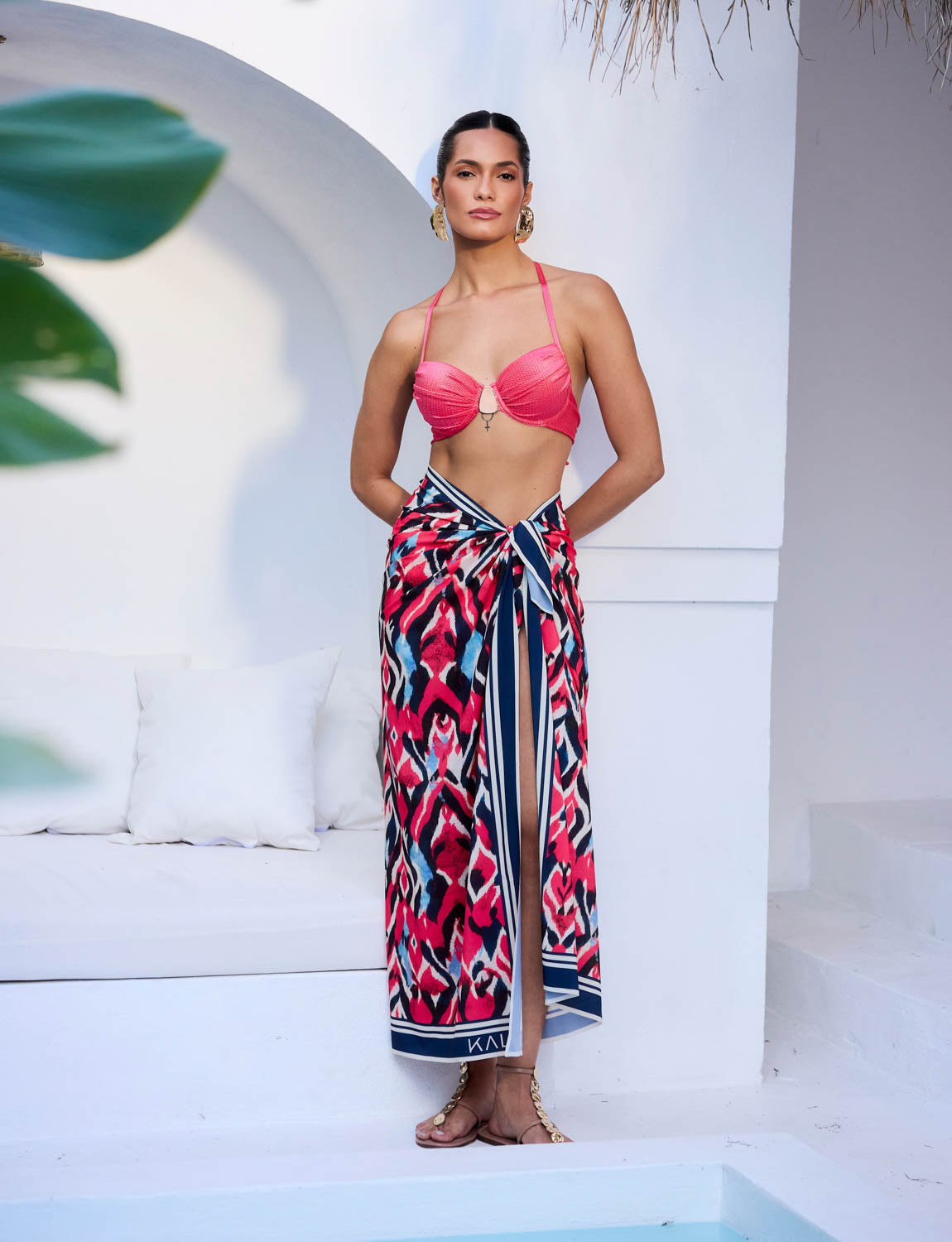 Saia pareô Lavis Kalini Beachwear com amarração frontal e fenda longa em cenário resort sofisticado