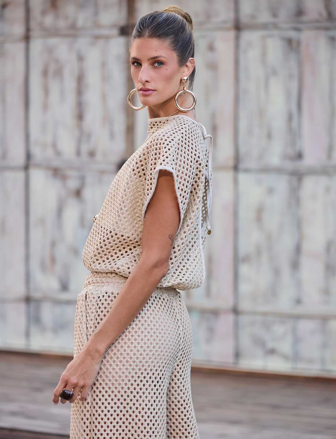Blusa ampla de trama aberta com textura inspirada no crochê usada em composição leve de beachwear
