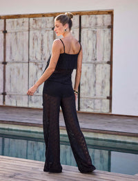 Blusa preta de renda Kalini com modelagem assimétrica e alças finas em composição elegante para resort