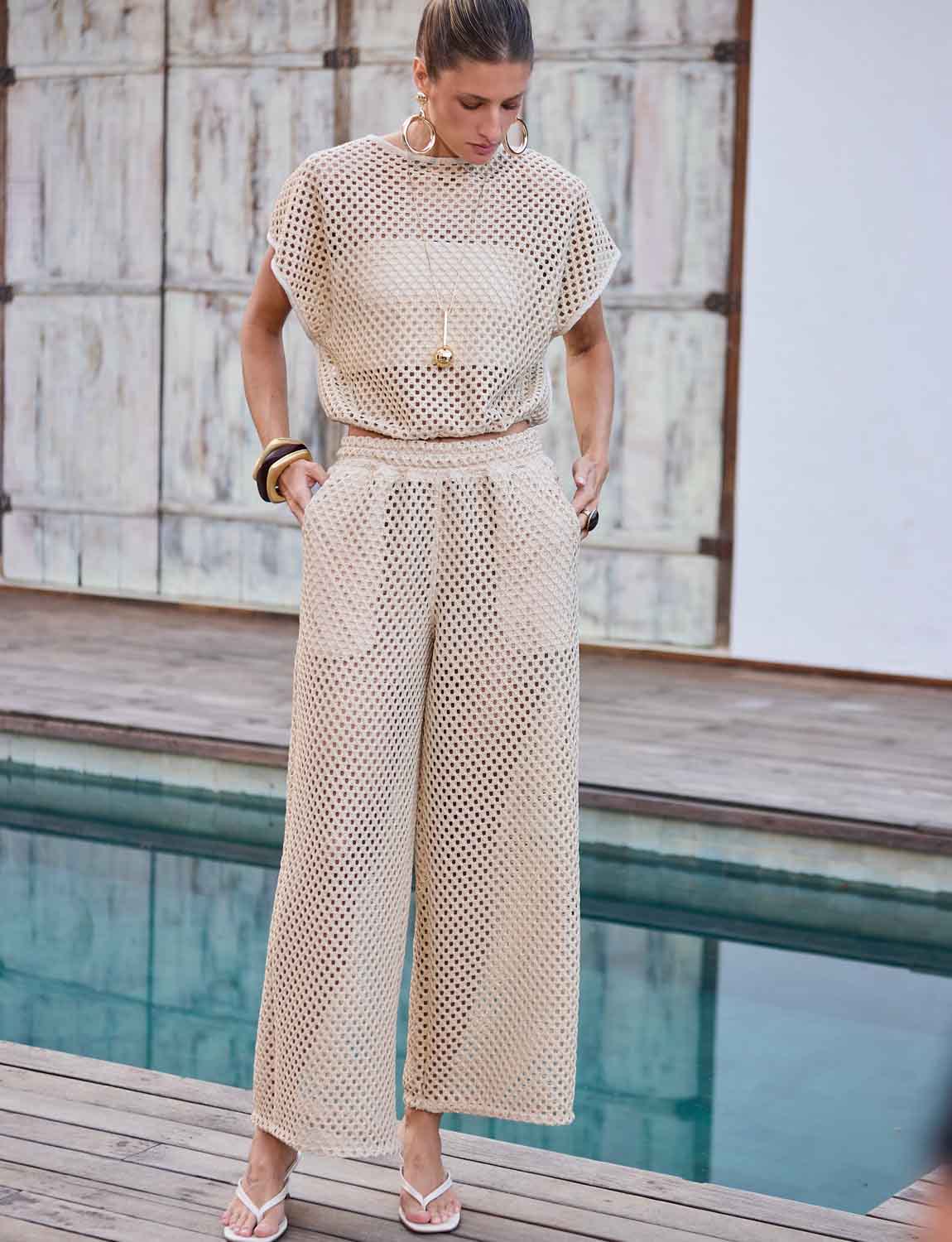 Modelo veste calca e blusa conjunto croche glow
