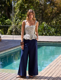 Mulher usando calça pantalona azul-marinho Kalini com modelagem ampla e fluida