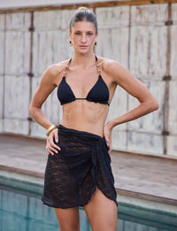 Saia pareô preta de renda Kalini com efeito transpassado e modelagem curta para look de beachwear sofisticado