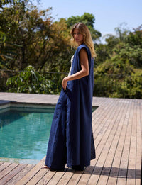 Mulher com vestido longo azul marinho em produção sofisticada de resortwear da Kalini