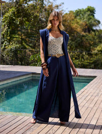 Mulher com vestido longo azul marinho em produção sofisticada de resortwear da Kalini